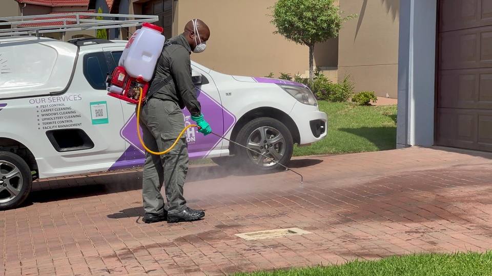 Fresh Lavation pest control technician spraying driveway